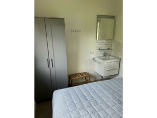 Schlafzimmer 2 mit Doppelbett, Schrank und Waschtisch