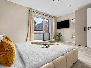 Schlafzimmer mit Doppelbett und TV