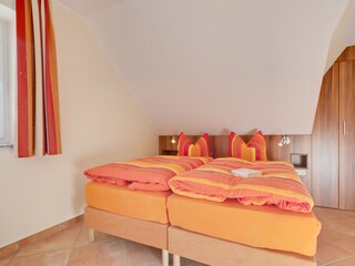 Schlafzimmer mit Doppelbett und separatem Klappbett