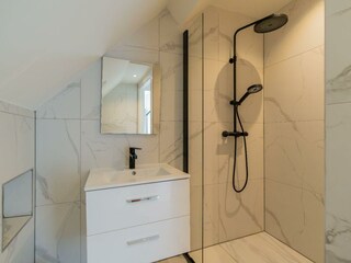 Modernes Badezimmer mit Regendusche, Waschbecken und WC