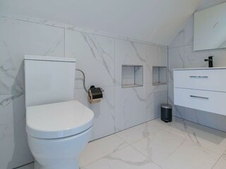 Modernes Badezimmer mit Regendusche, Waschbecken und WC