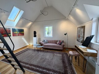 Blick ins Wohnzimmer mit Arbeitsplatz