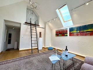 Wohnzimmer mit Leiter zum Schlafalkoven