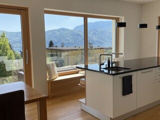 Küchenbereich neben Esstisch mit Seeblick