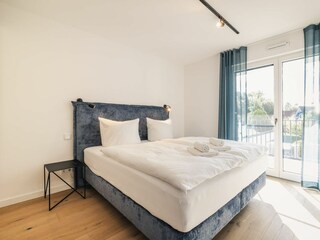 Schlafzimmer mit TV Gerät und Balkon