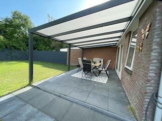 Ein Garten mit Terrasse und Veranda.