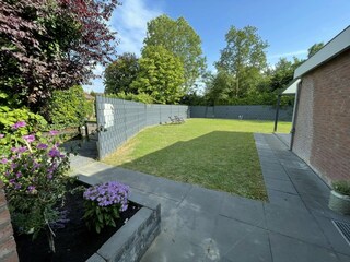 Ein Garten mit Terrasse und Veranda.