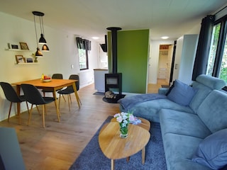 Wohnzimmer mit Kamin und offenem Übergang zur Küche