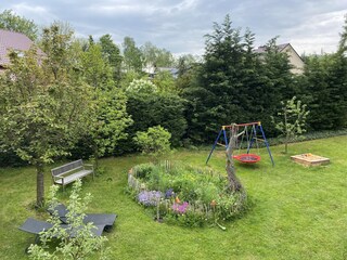 Garten mit Blühinsel und Kinderspielplatz