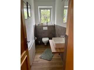 Kleines Bad mit WC und Waschbecken.