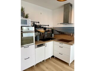 Küche mit Backofen, Herd, Mikrowelle und Spülmaschine