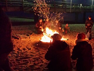 Lagerfeuer mit Glühwein am Strand.