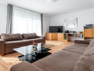 Wohnzimmer mit zwei Schlafsofas und Bio-Kamin