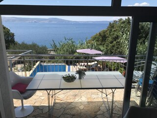 Balkon mit Pool und Meerblick.
