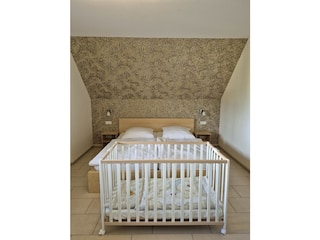 Schlafzimmer mit Babybett auf Gästewunsch