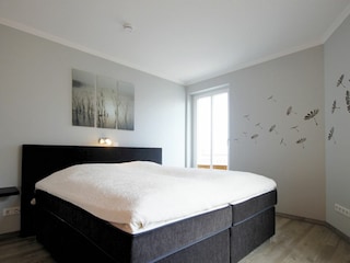 Schlafzimmer mit weiterem Zugang zum Balkon.