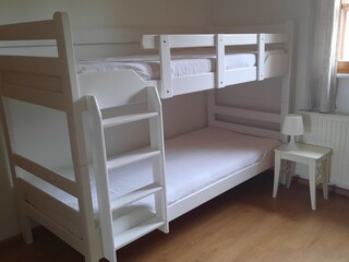 Kinderzimmer mit Stockbett und einem Einzelbett