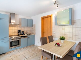Wohnzimmer mit Zugang zur Terrasse, Essbereich und Küchenzeile