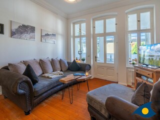 Wohnzimmer mit offener Küche und Zugang zur Loggia