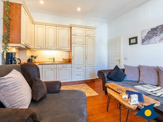 Wohnzimmer mit offener Küche und Zugang zur Loggia