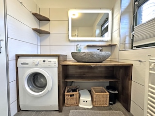 Badezimmer mit Waschmaschine und Dusche