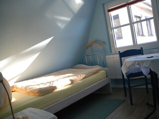 Spitzboden andere Seite mit Einzelbett und Sitzbereich