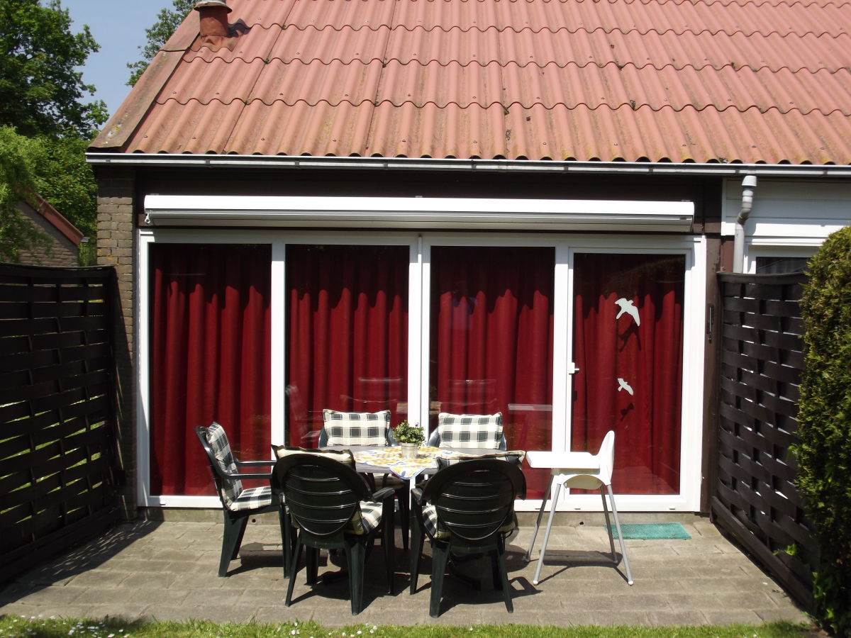 Terrasse mit Gartenmöbel, Kinderhochstuhl und Markise