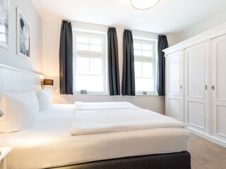 Schlafzimmer mit Doppelbett und großem Kleiderschrank