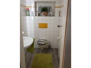 WC getrennt vom Duschbad mit Warmwasser am Waschbecken