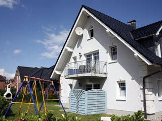 Hausnasicht mit Garten Spielplatz und Grillkamin
