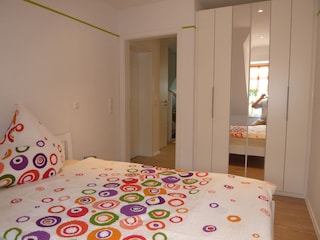 Schlafzimmer mit Doppelbett und Spiegelschrank