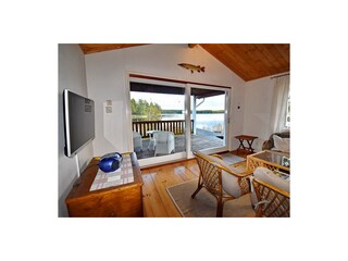Blick aus dem Wohnraum über die Veranda zum See