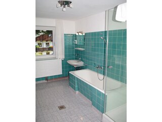 the spacious bathroom with bathtub, shower and sink