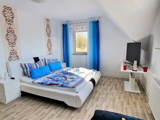 Schlafzimmer mit großem Doppelbett und Schlafcouch