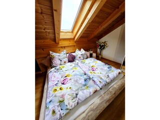 Rundholzstammbett  im Schlafzimmer oberes Stockwerk