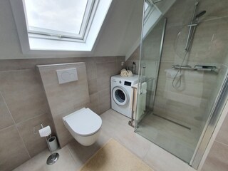 Badezimmer mit barrierefreie Dusche WC und Waschbecken