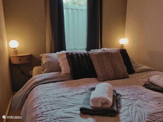 das Hauptschlafzimmer mit gemachtem Bett