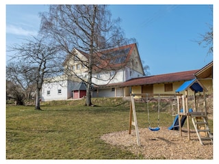 Haus vom Garten mit Spielplatz aus