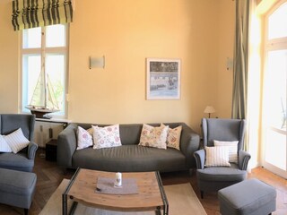 Das Wohnzimmer mit Sofa und Ohrensesseln