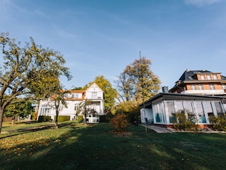 Der Bungalow mit der Villa im Hintergrund
