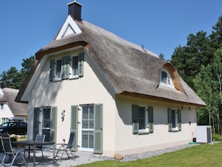Blick aufs Ferienhaus und die Terrasse mit Gartenmöbeln