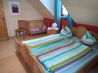 Elternschlafzimmer mit Kinderbettchen