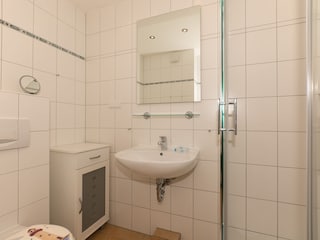Badezimmer mit Glasdusche, Waschtisch und WC