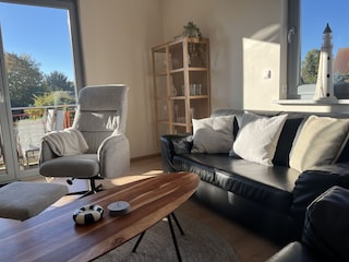 Wohnzimmer mit Relaxsessel und Sofas