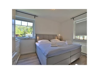 Ostseegarten - Blick in das Schlafzimmer mit einem Boxspringbett