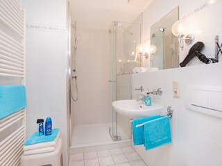 large and bright bathroom with hairdryer &  shelf space