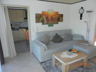 Wohnzimmer mit ausziehbarer Couch und 1 Sessel