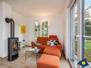 Wohnbereich mit Kamin und Zugang zur Terrasse