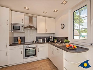 offene Küche mit Essplatz und Zugang zur Terrasse