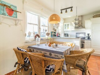 Wohnzimmer mit offener Küche und Zugang zum Balkon